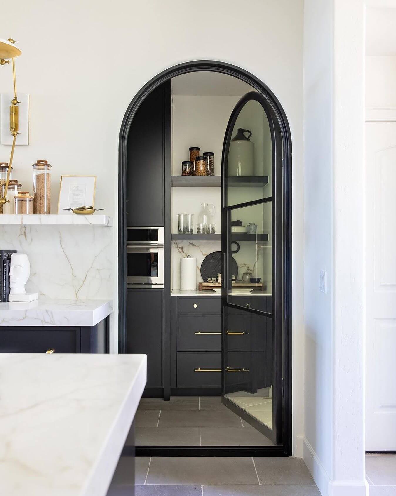 Arched Black Metal Door With Clear Panes Offers a Modern Entry