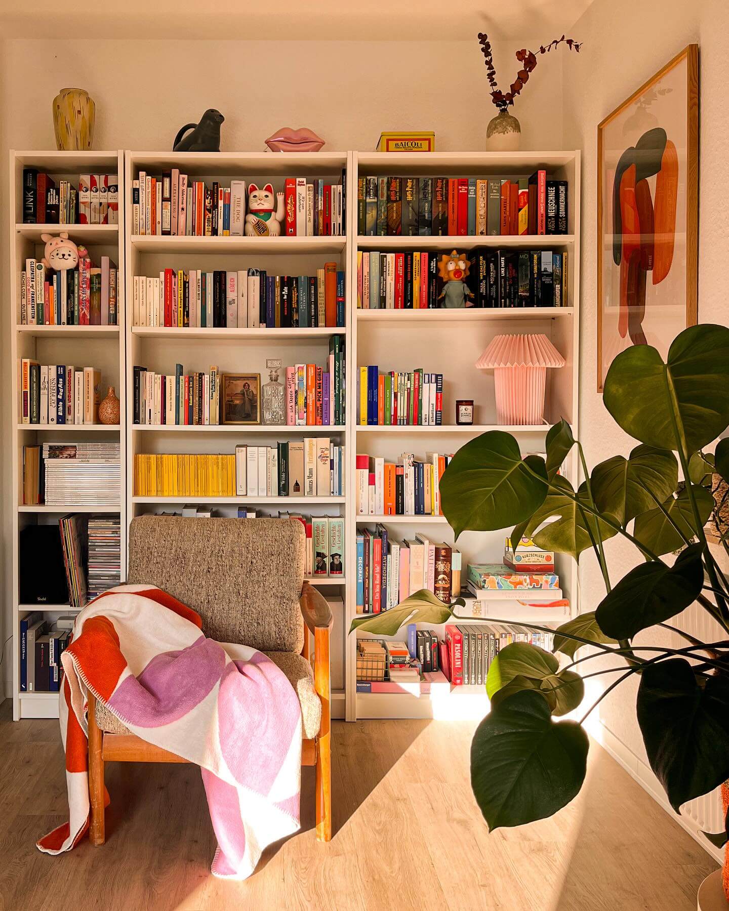 Pink pleated lamp adds a soft glow to bookshelves