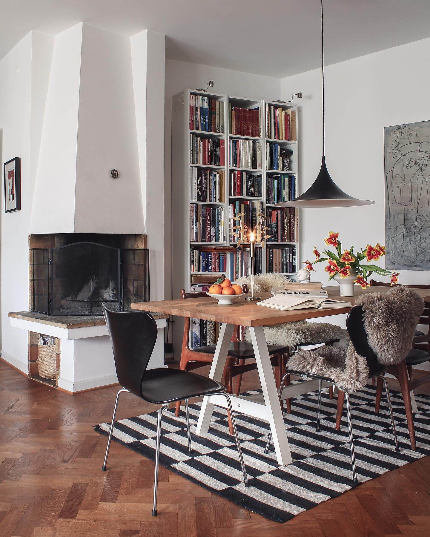 White bookshelves create a striking backdrop for a dining area