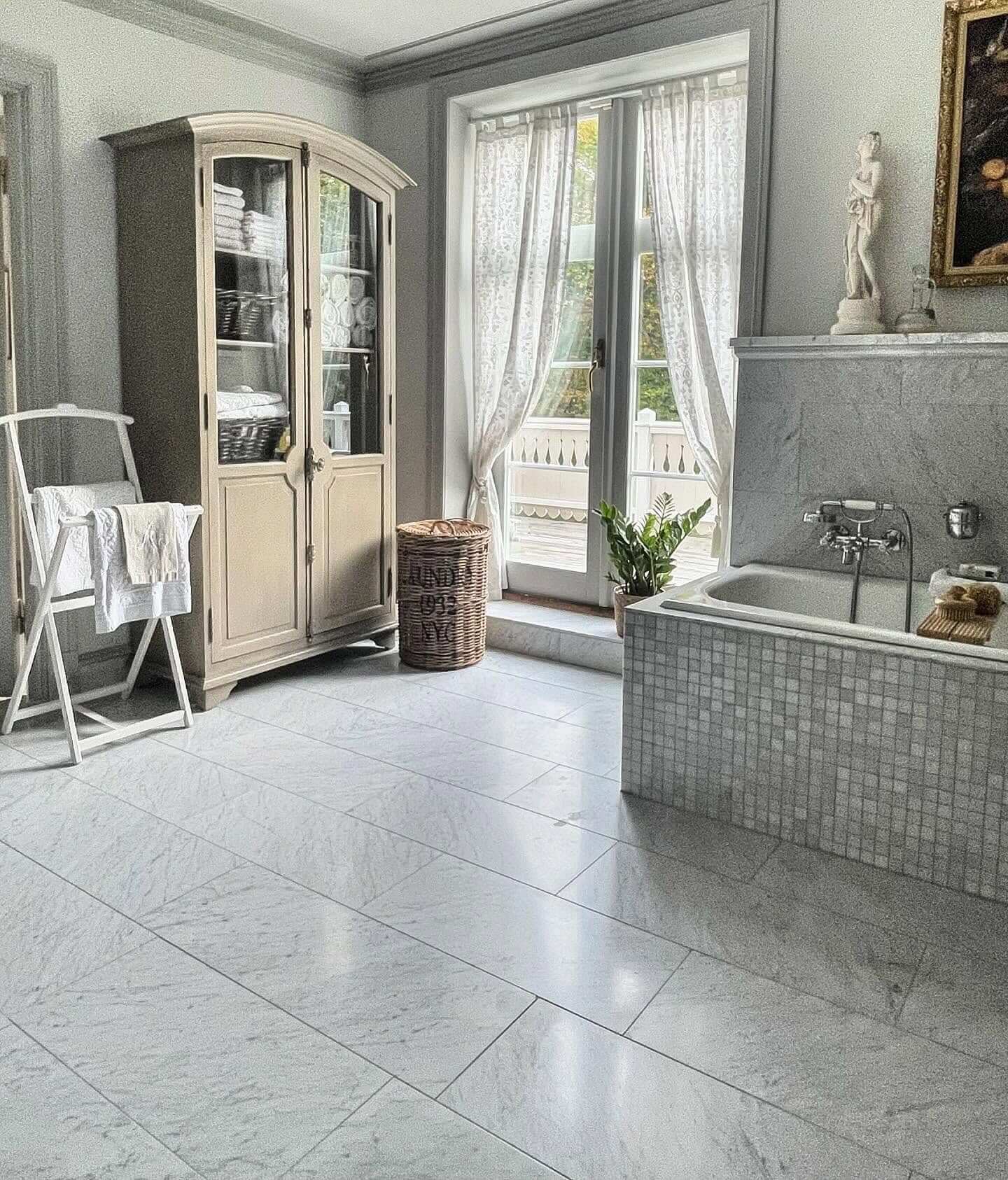 Curved Glass-Fronted Cabinet Stores Linens With Vintage Charm