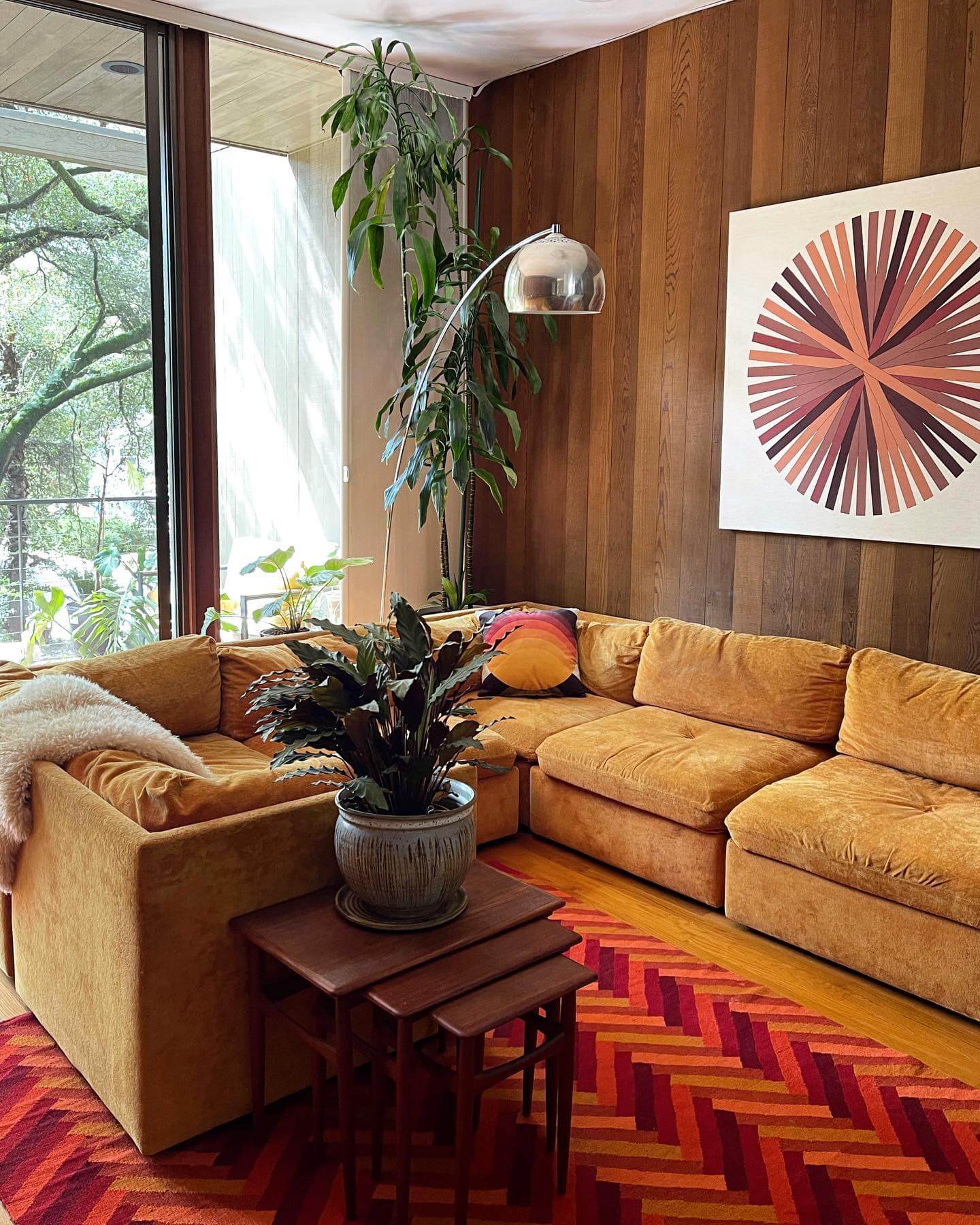 Sunburst Artwork Anchors Wood-Paneled Mid-Century Walls