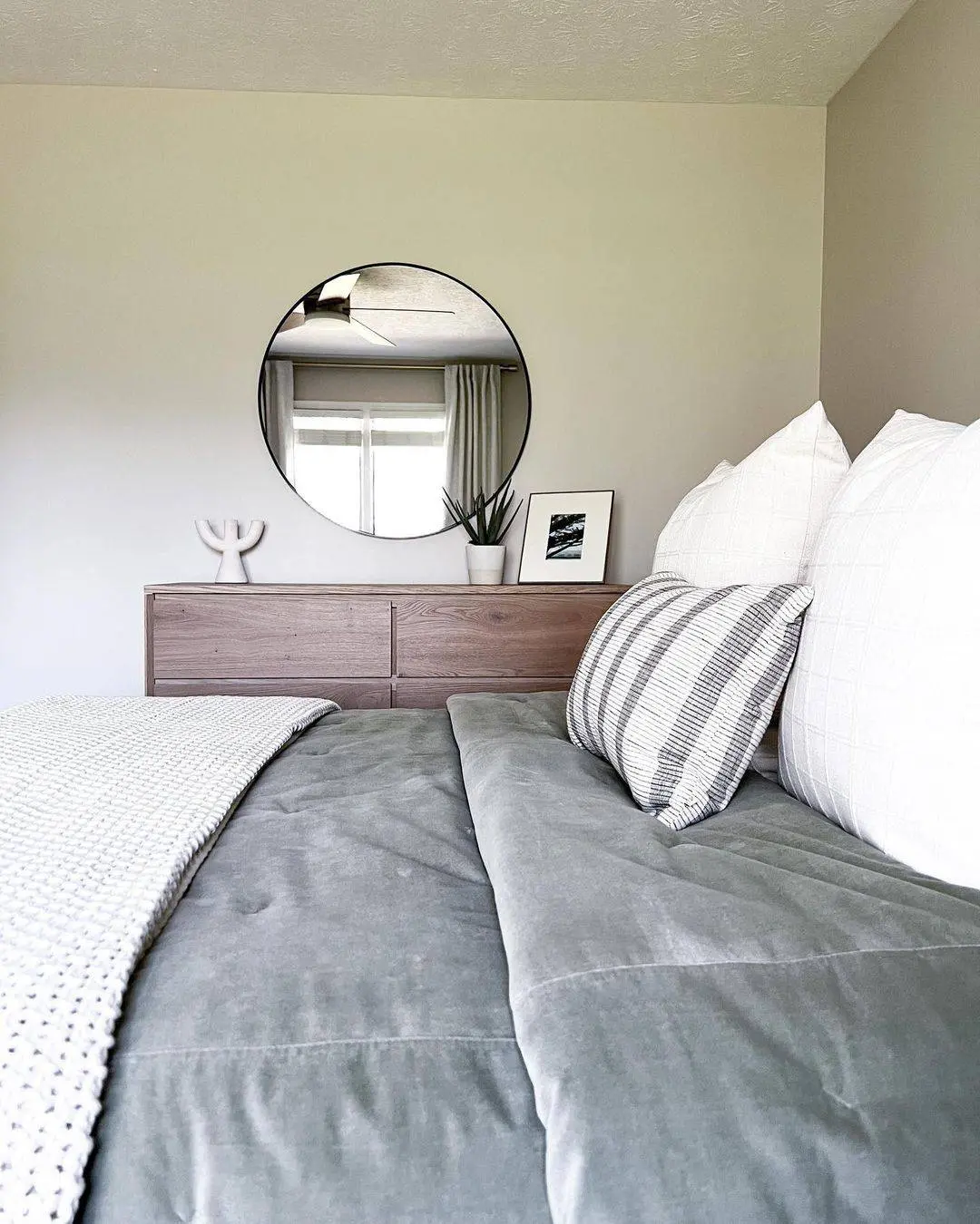 Round Black Mirror Adds a Graphic Focal Point Above Dresser