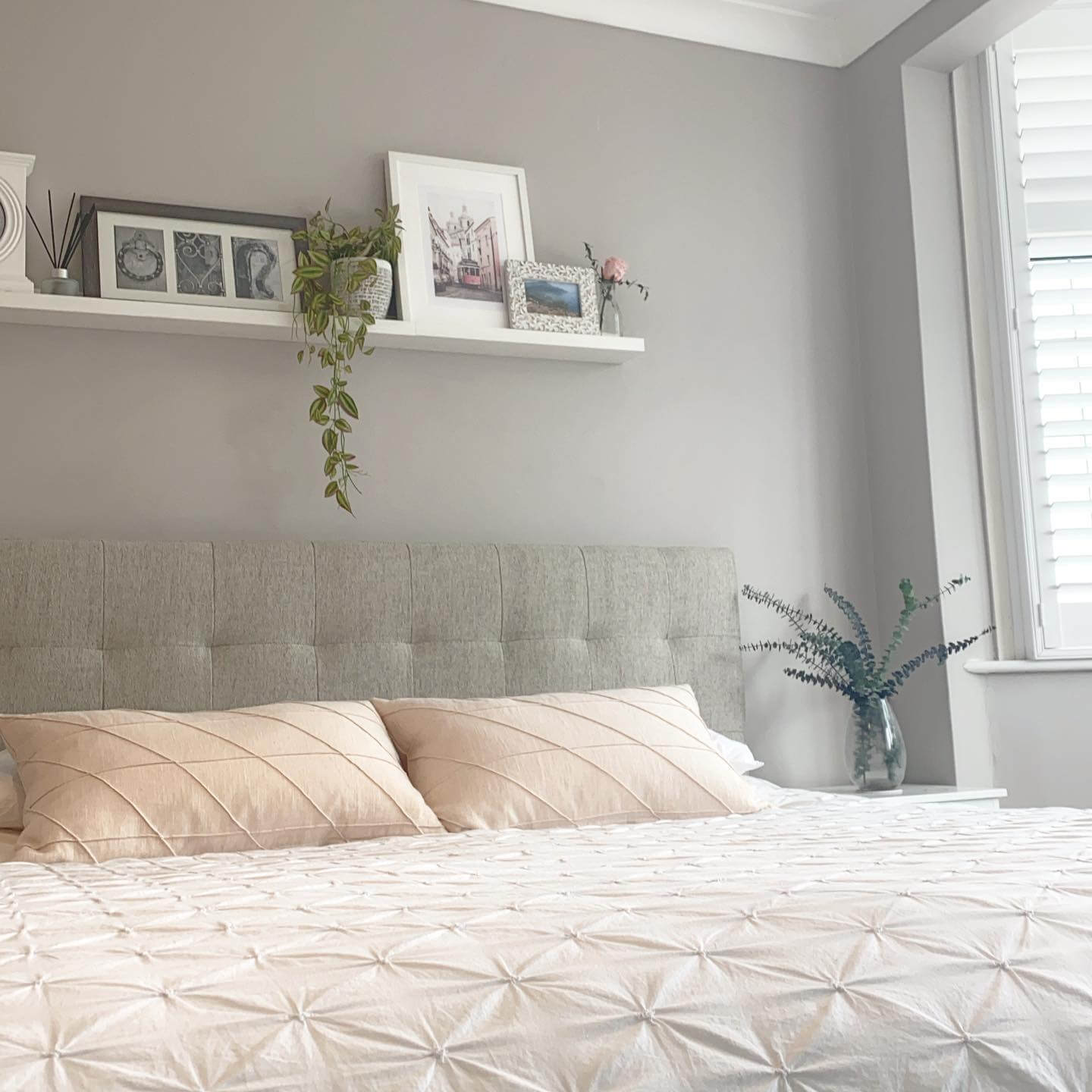 Layer Framed Art and Greenery on White Shelves