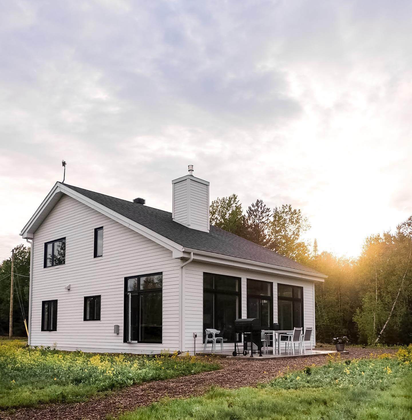 White Siding and Black Window Frames Define a Modern Farmhouse Silhouette