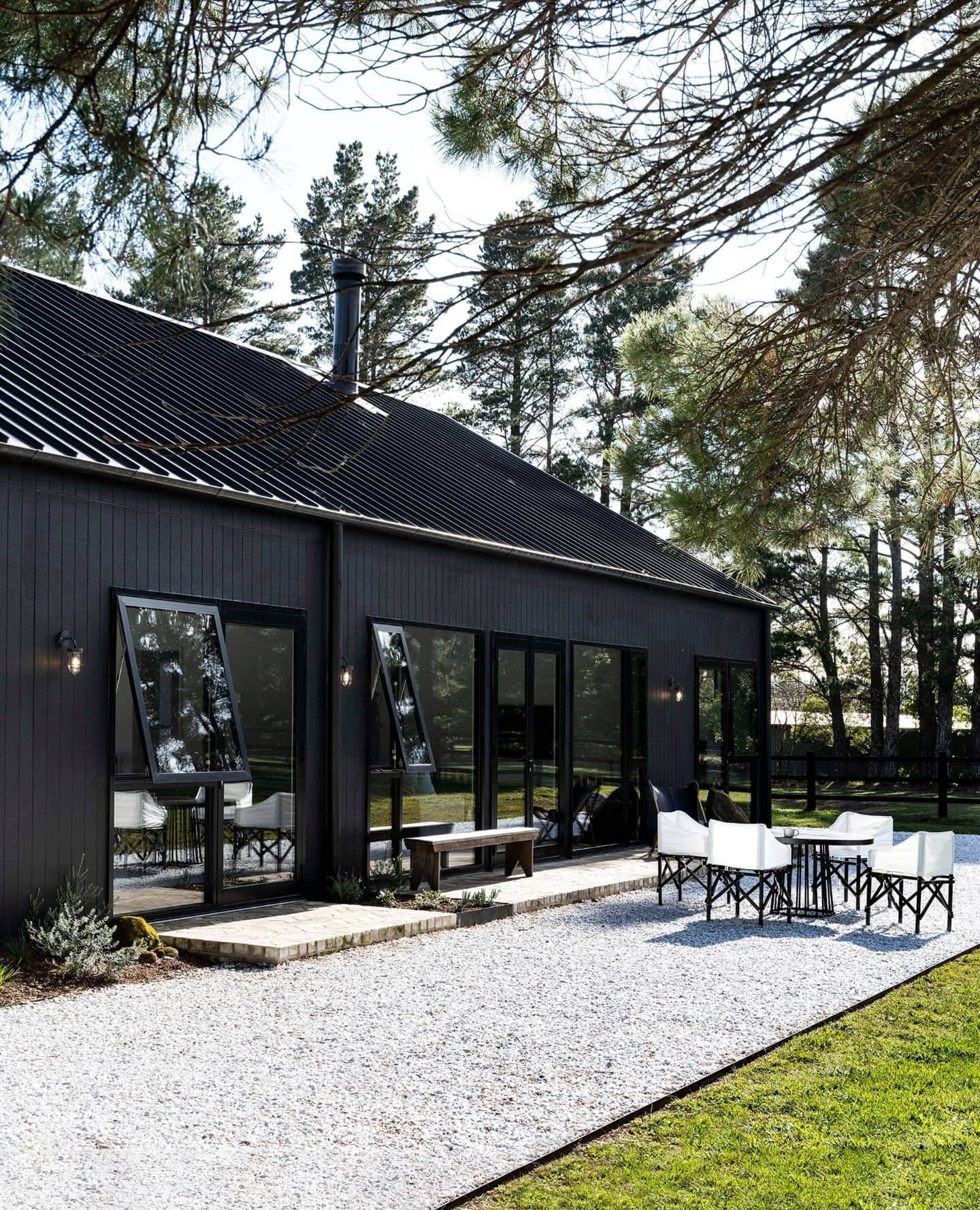 Dark Vertical Siding and Black Trim Create a Sleek Modern Farmhouse