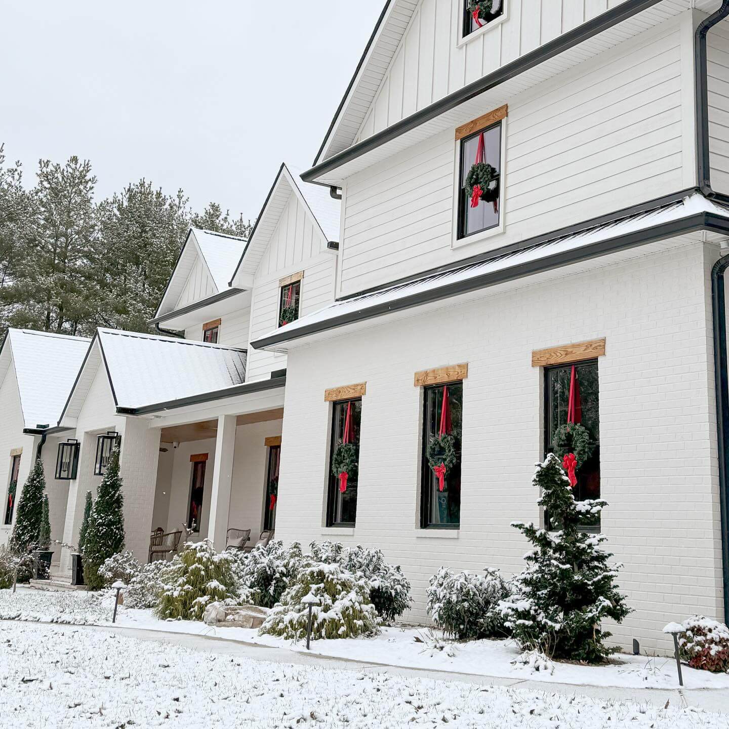 Wooden Window Trim Frames Festive Wreaths With Red Ribbons