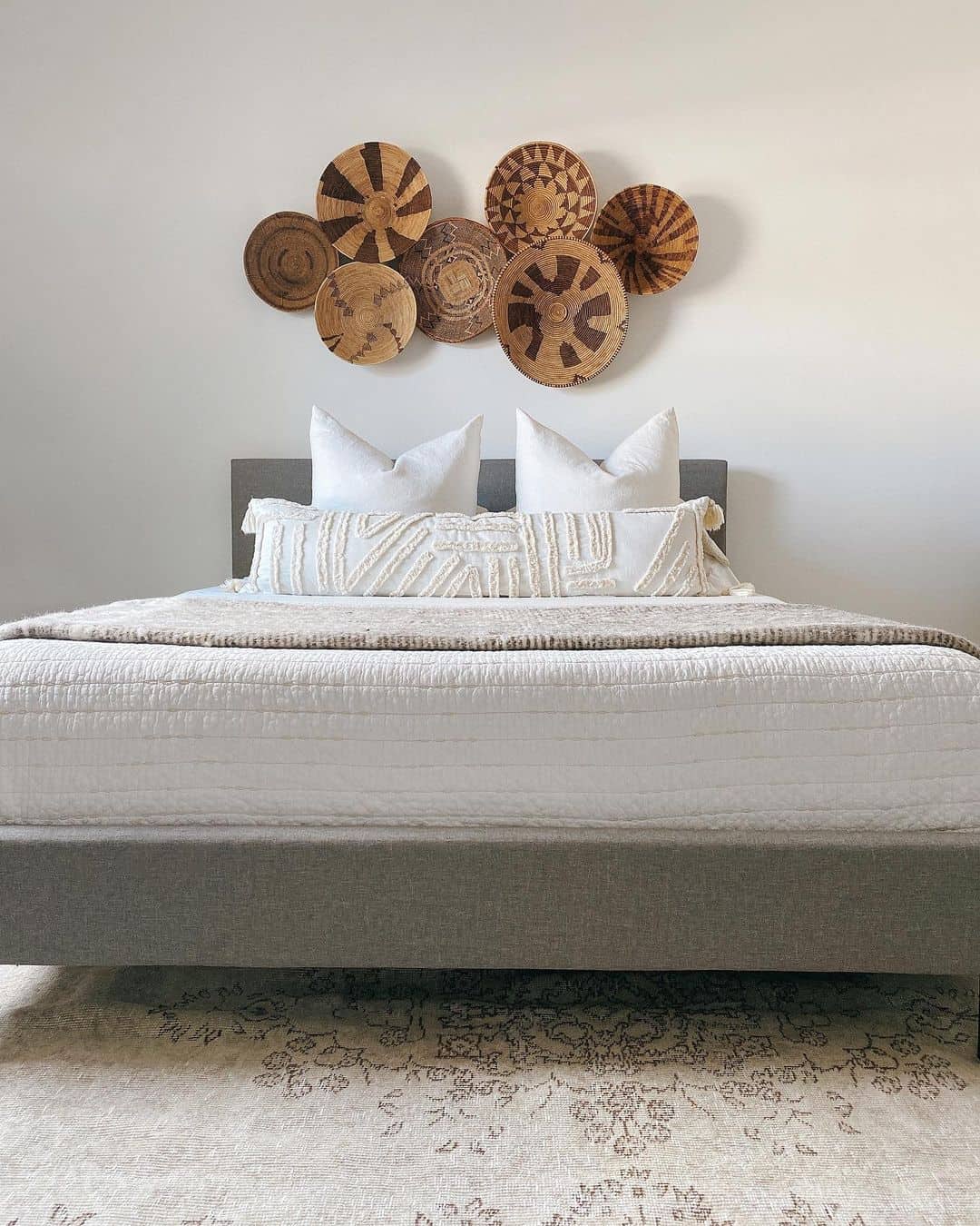 Grouped Round Baskets Add Natural Texture Above Bed