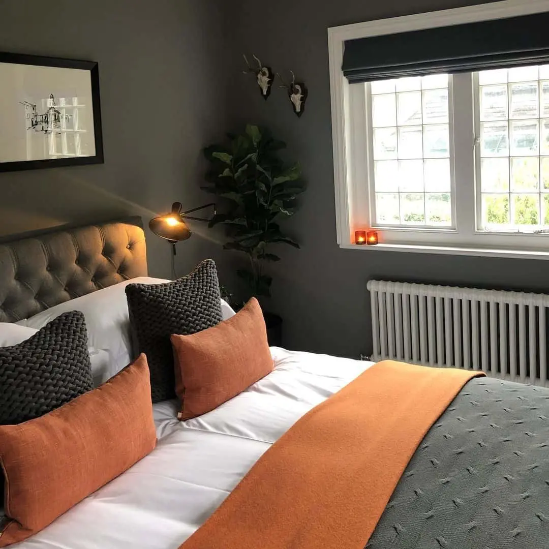 Warm Orange and Charcoal Pillows Create a Cozy Bedside