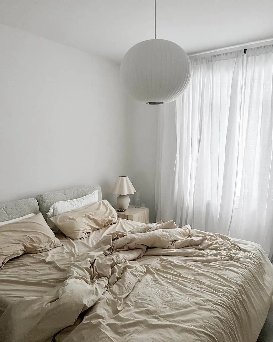 Large Orb Pendant Light Softens a Minimalist Bedroom
