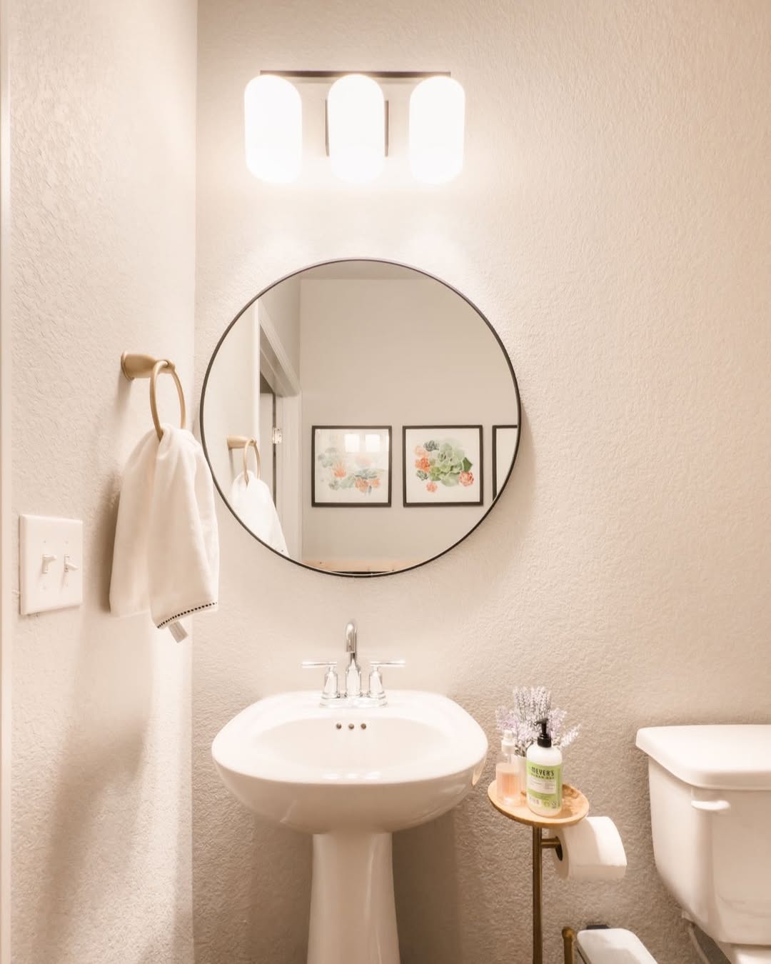 Three Capsule-Shaped Lights Add Soft Illumination Above the Mirror