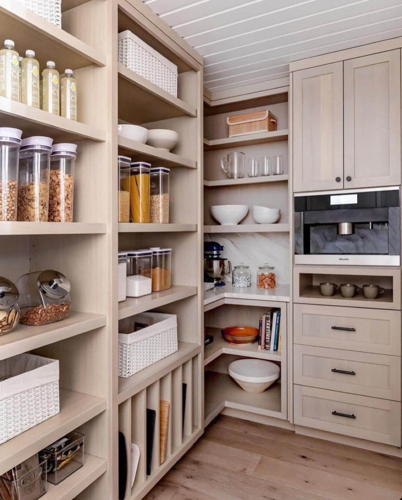 Corner shelving with a marble backsplash creates a stylish pantry nook