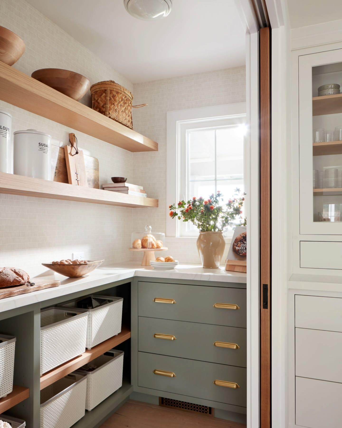 Sage green drawers with brass pulls add color and modern flair