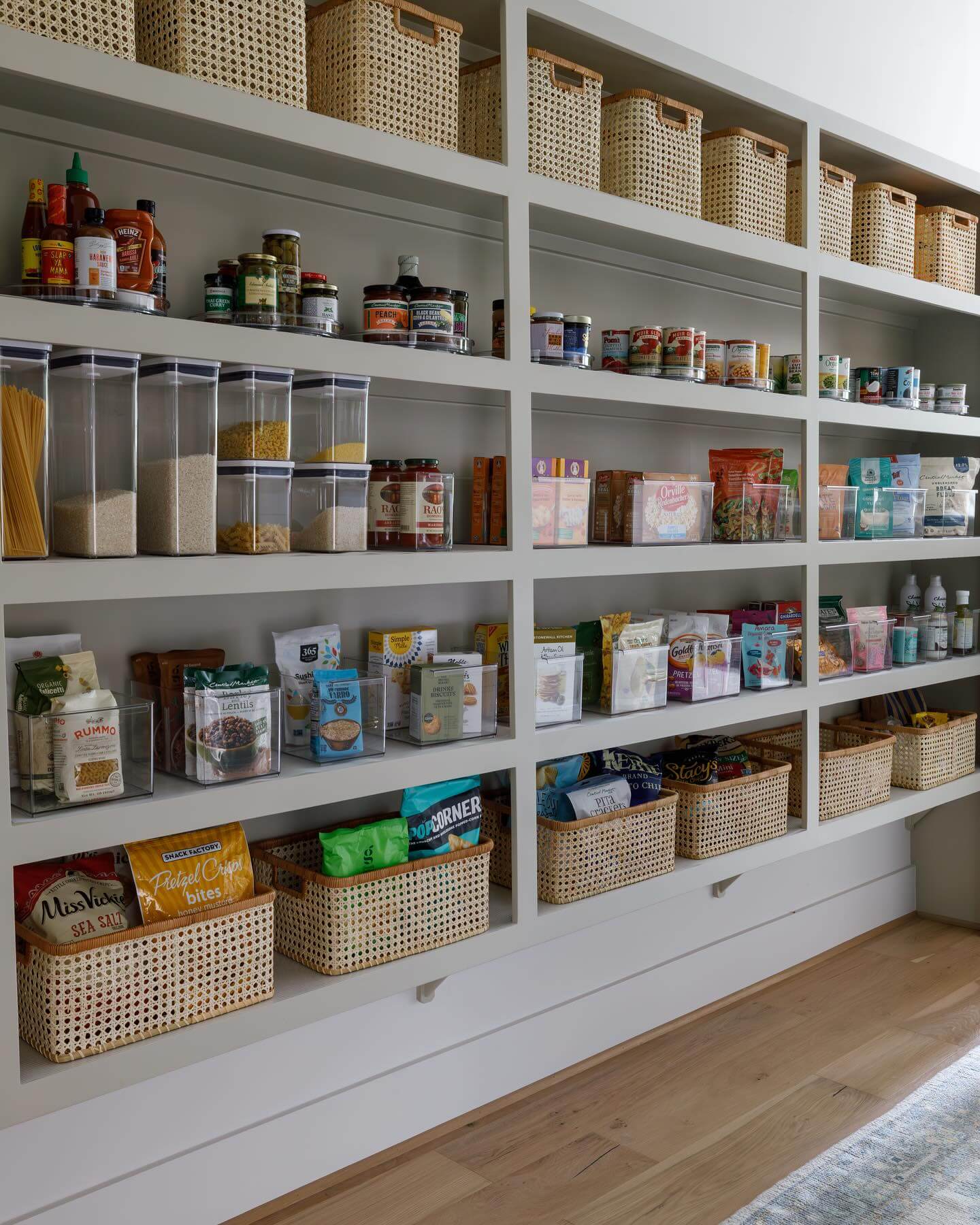 Woven cane baskets add natural texture to pantry shelves