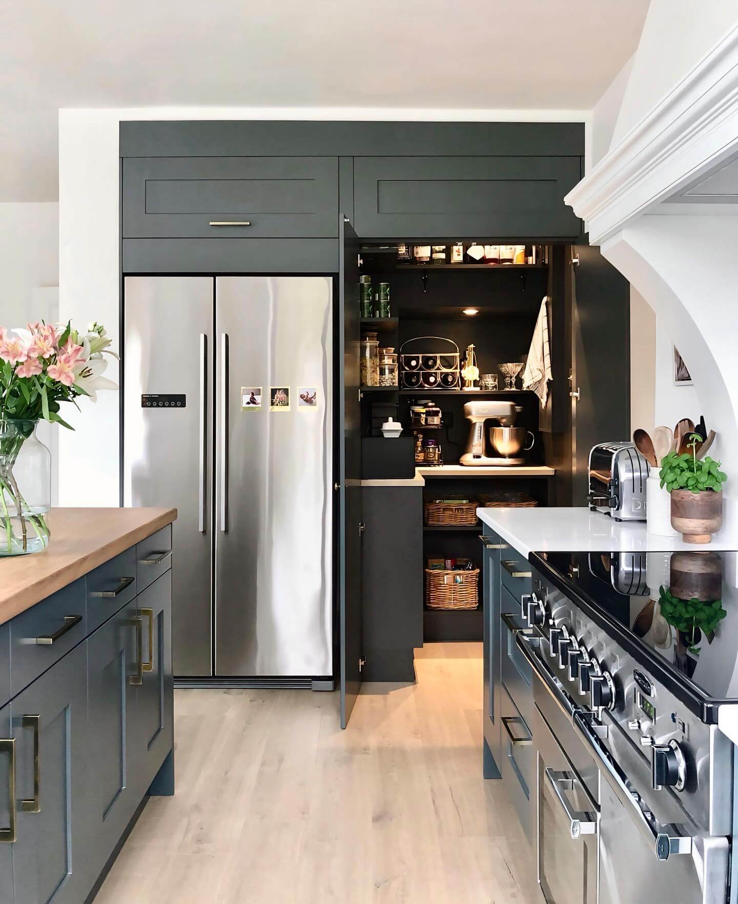 Dark pantry shelves feature a built-in rack for wine bottles