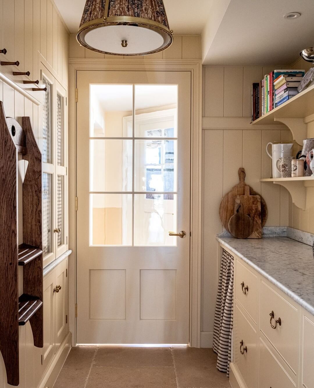 Wooden peg rails near the door keep kitchen essentials handy