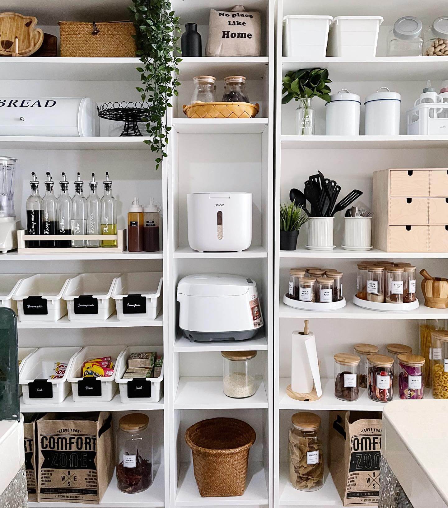 White bins with black labels organize pantry staples