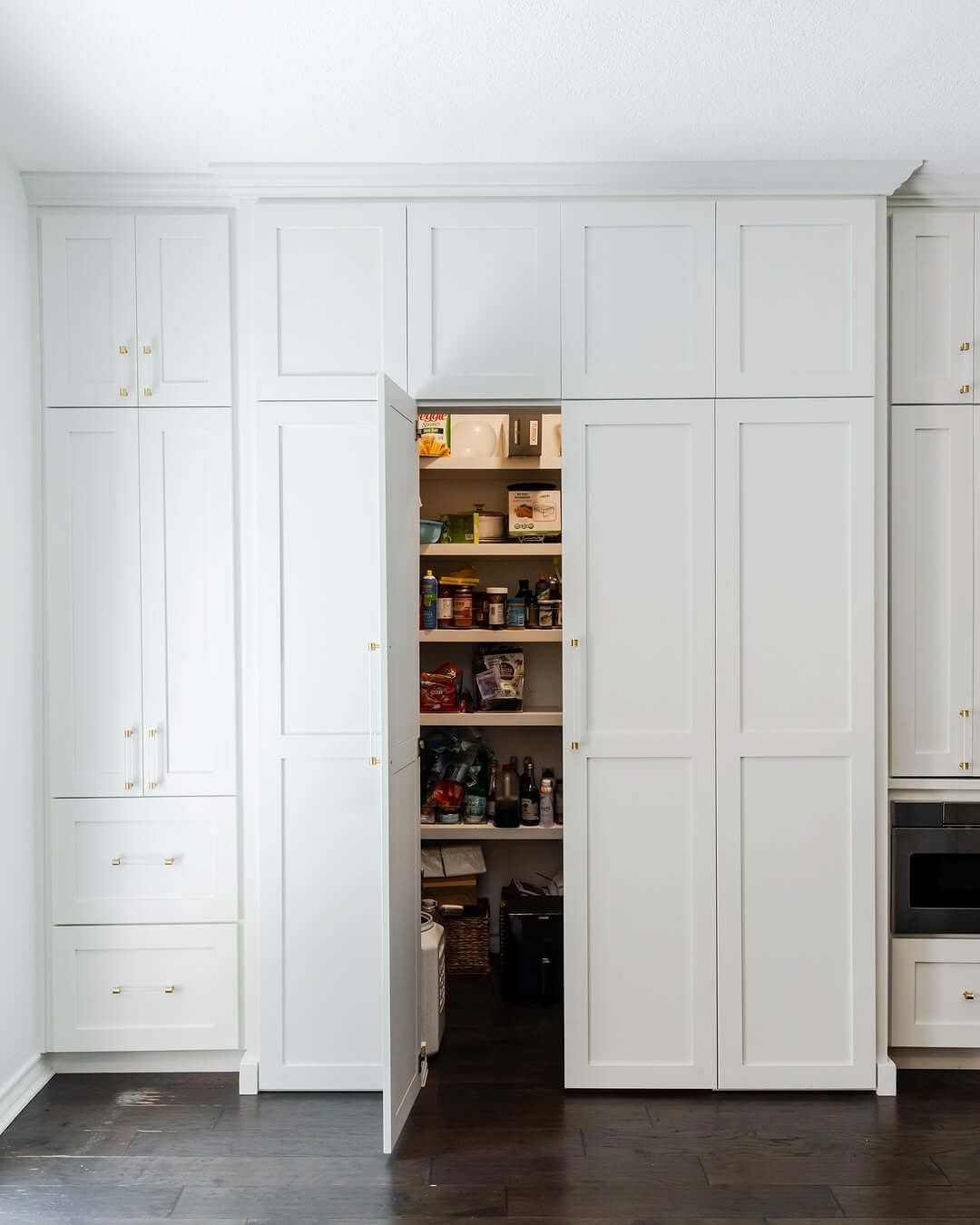White Shaker-Style Doors Conceal a Deep Pantry