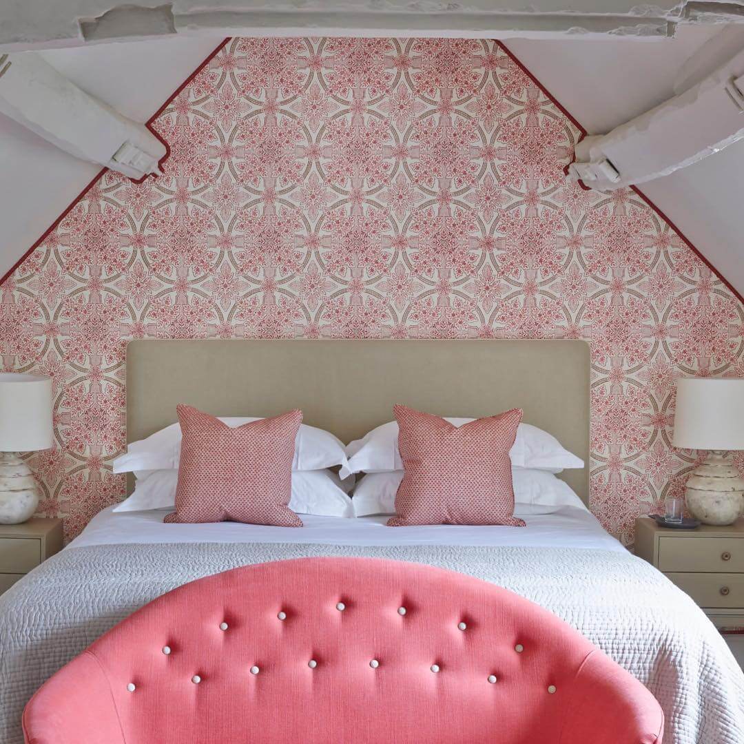 Patterned Pink Wallpaper Frames the Bed With Architectural Detail