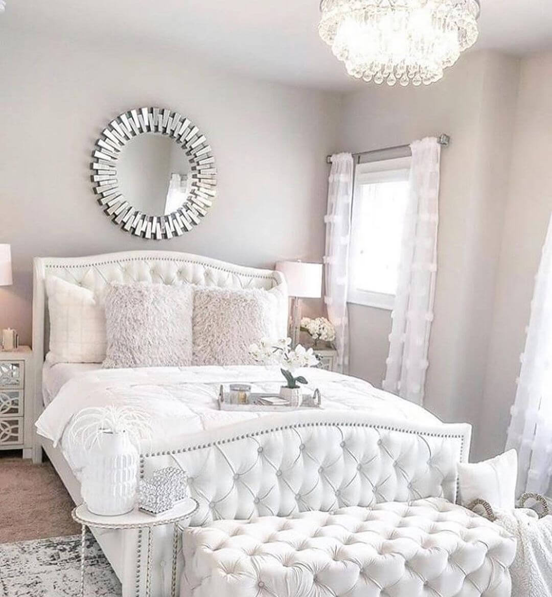 Mirror With Sunburst Frame Adds Glamour Above a Tufted Headboard
