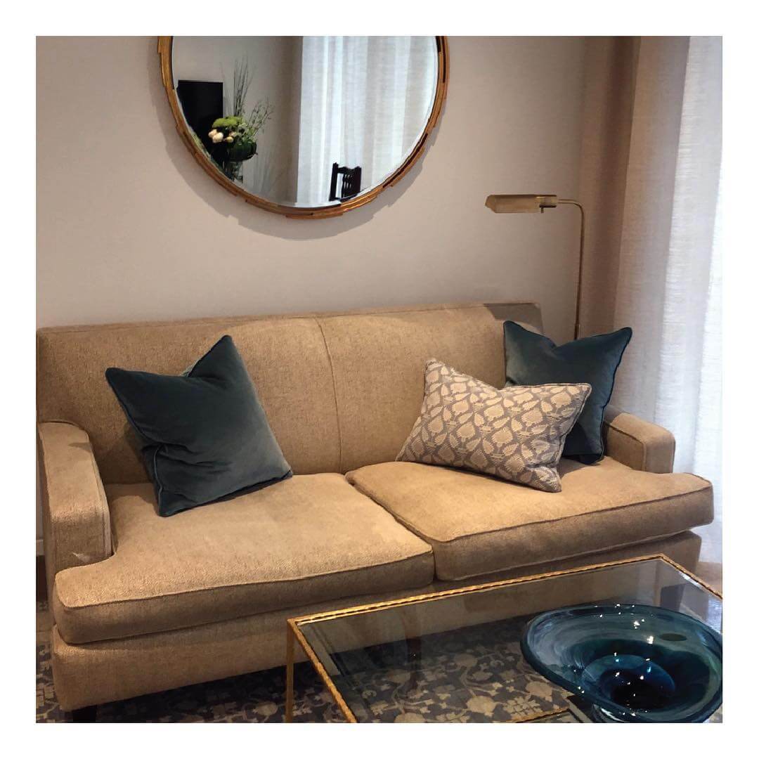 Round Mirror Reflects Light and Adds Depth Above Sofa