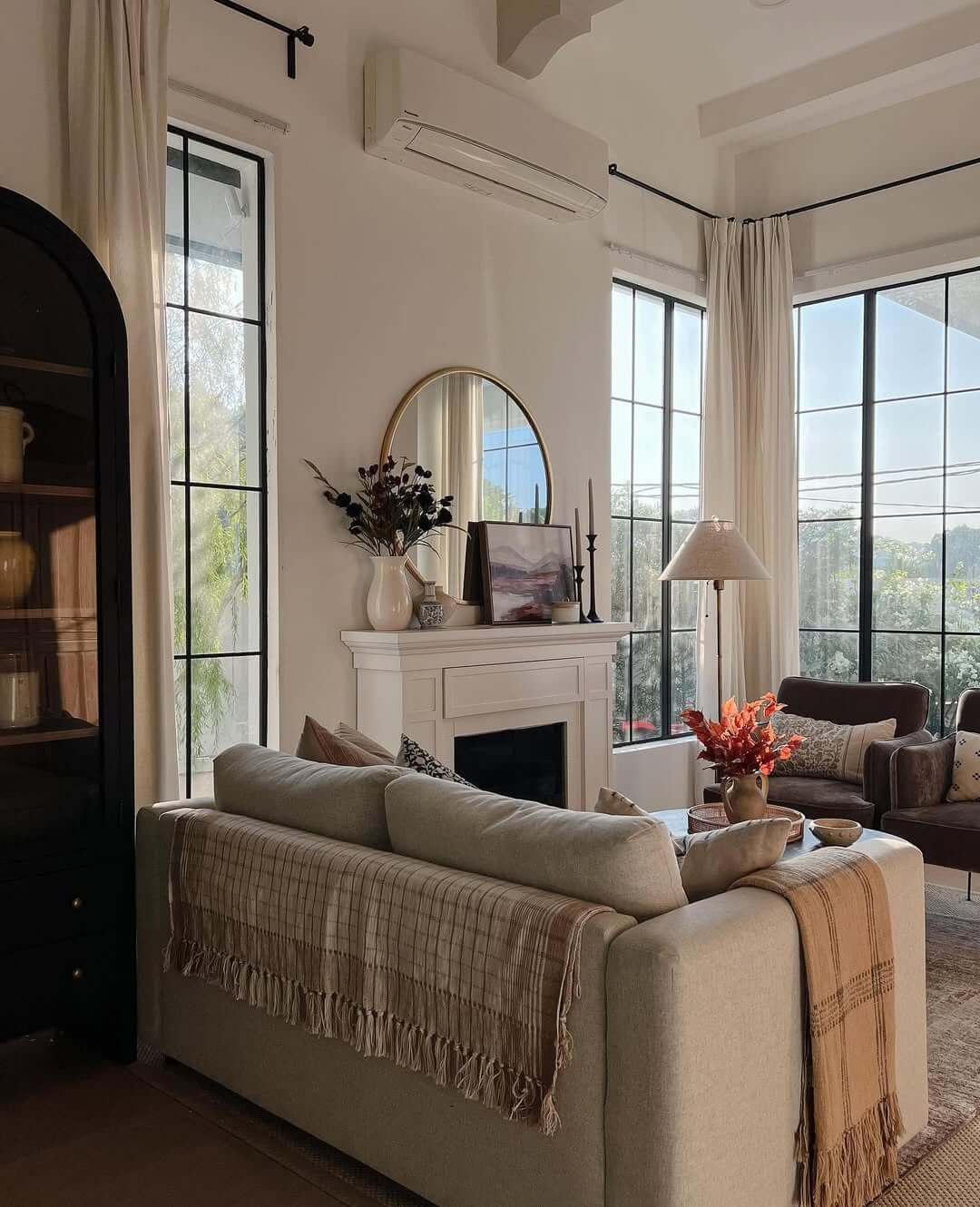 Round Mirror Adds a Warm Focal Point Above the Fireplace