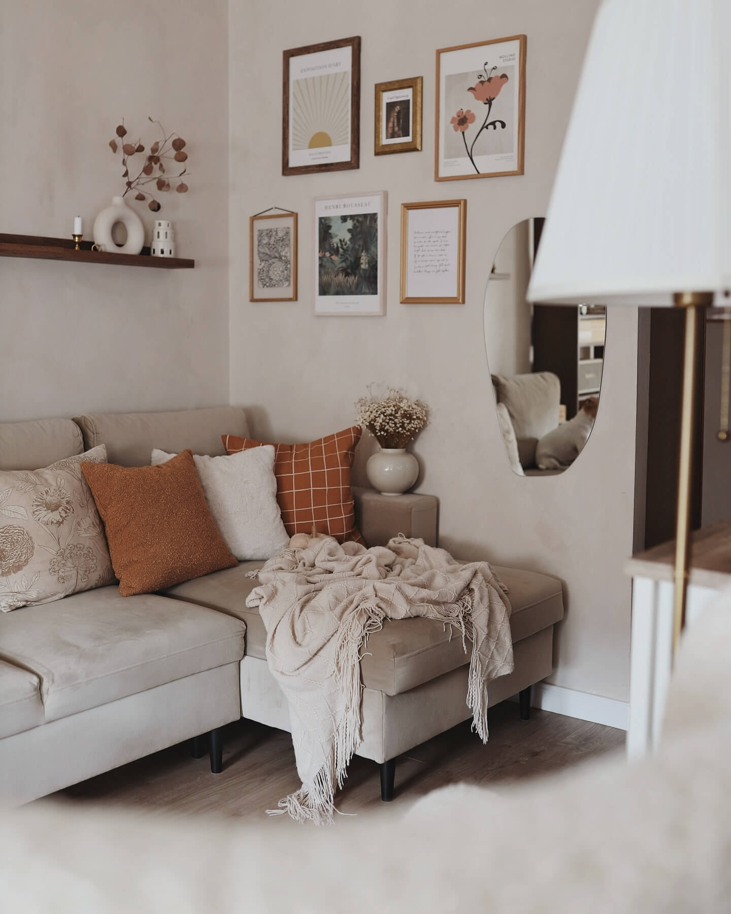 Gallery Wall of Art and Mirror Adds Depth Above Sofa