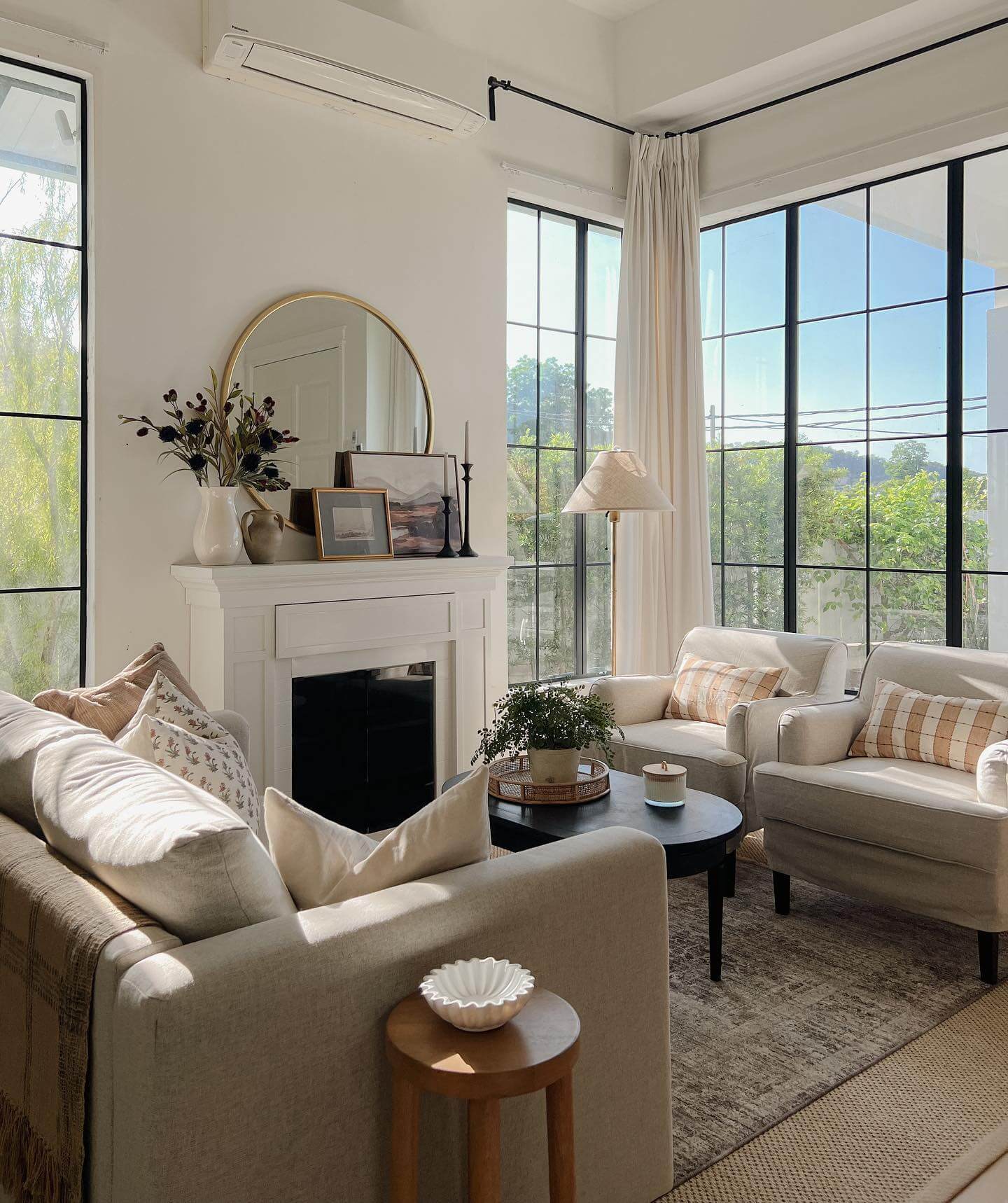 Round Mirror Above Fireplace Reflects Light and Adds Depth