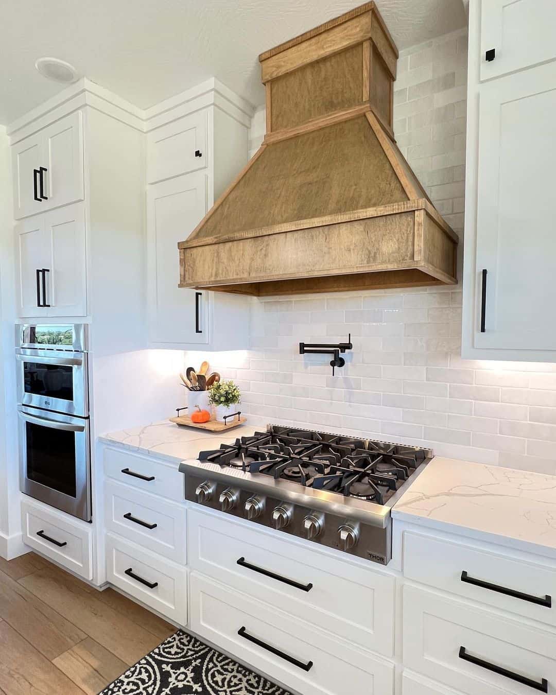 White Brick Pattern Backsplash With a Wood Range Hood
