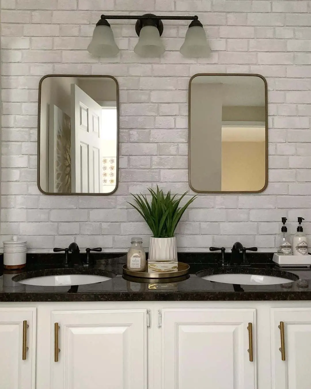Round-Cornered Mirrors Contrast Brick-Patterned Backsplash