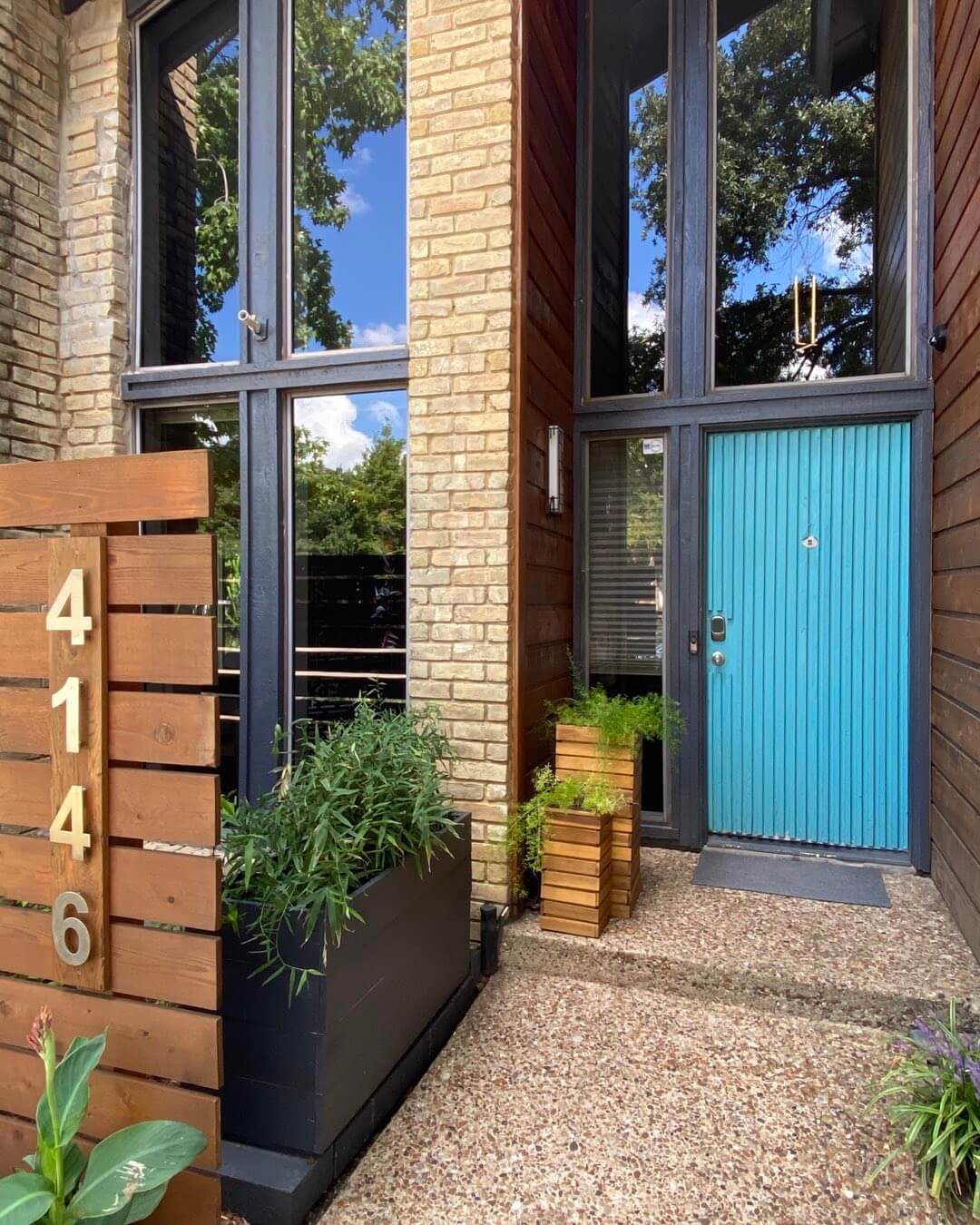 Bright Teal Door With Stacked Wooden Planters
