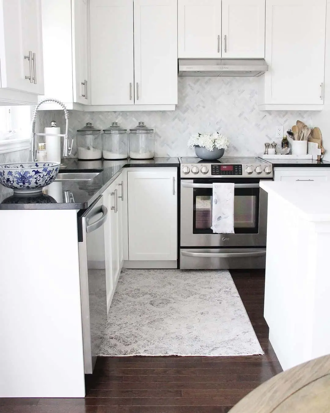 Marble Herringbone Backsplash With Minimalist White Cabinetry