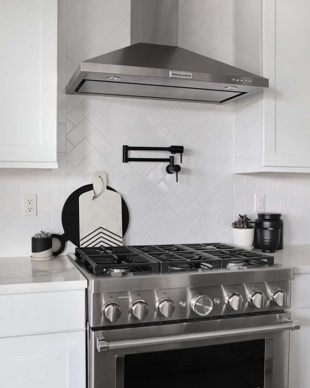 Black Pot Filler Faucet Adds Functional Contrast to White Herringbone Backsplash