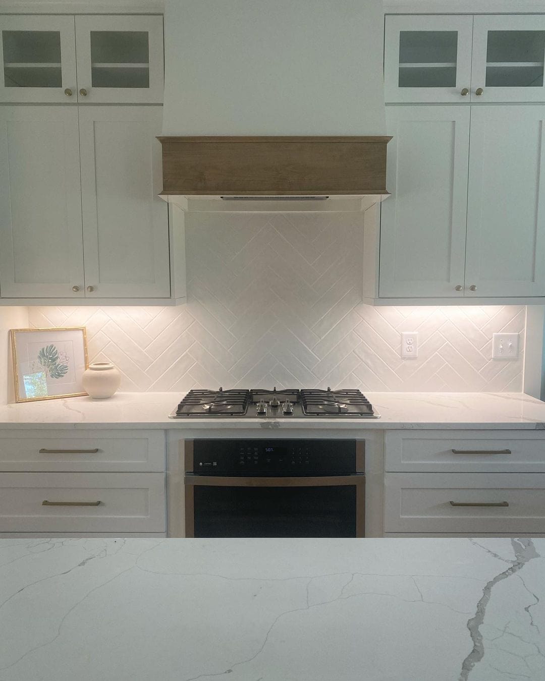 White Herringbone Tile Backsplash Adds Subtle Pattern to Cabinetry