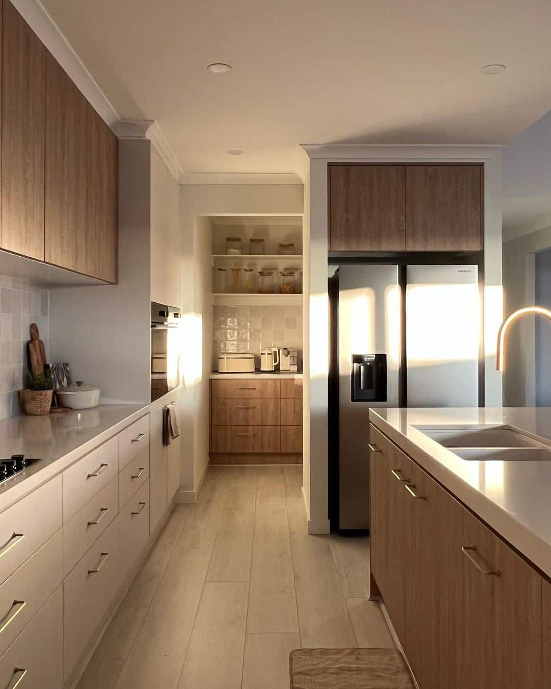 Warm Wood Drawer Fronts with Thin Brass Bar Pulls for Natural Texture