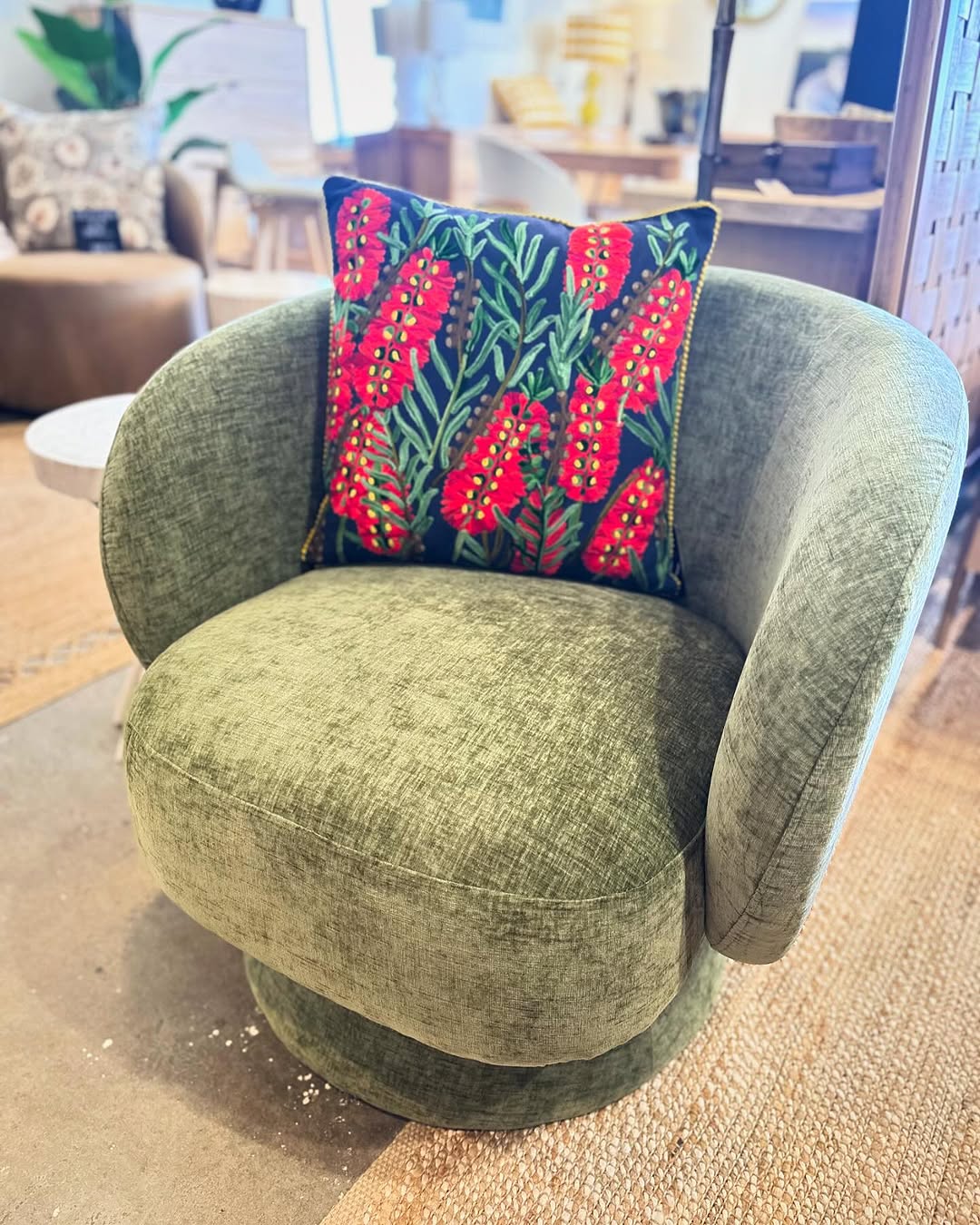 Olive Swivel Chair Anchored by a Bold Botanical Pillow