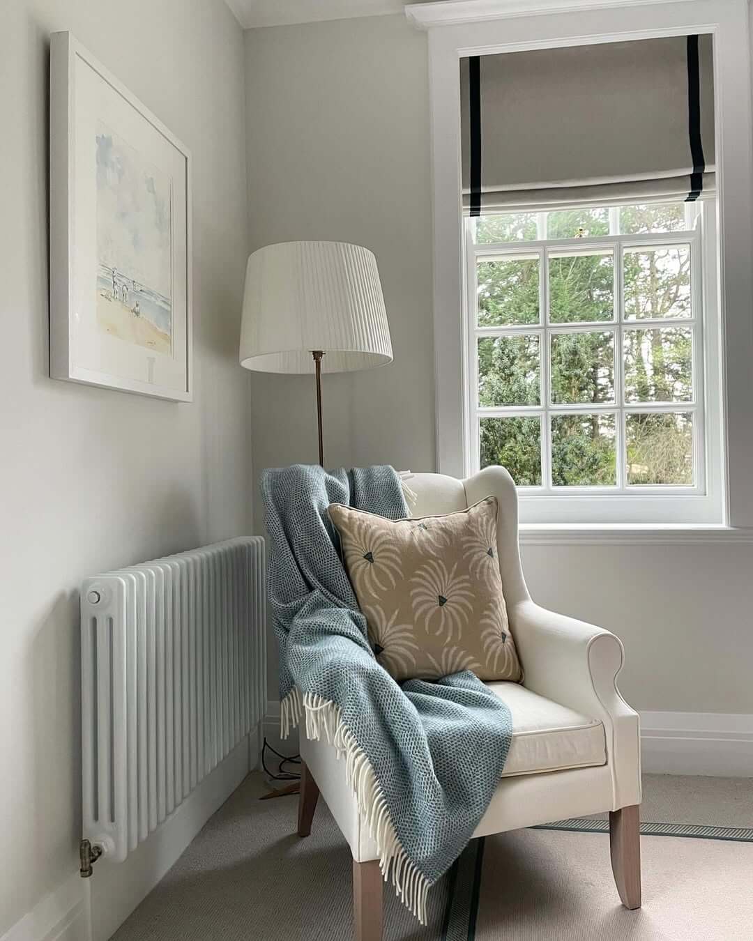 Cream Wingback Chair with Blue Throw and Patterned Pillow