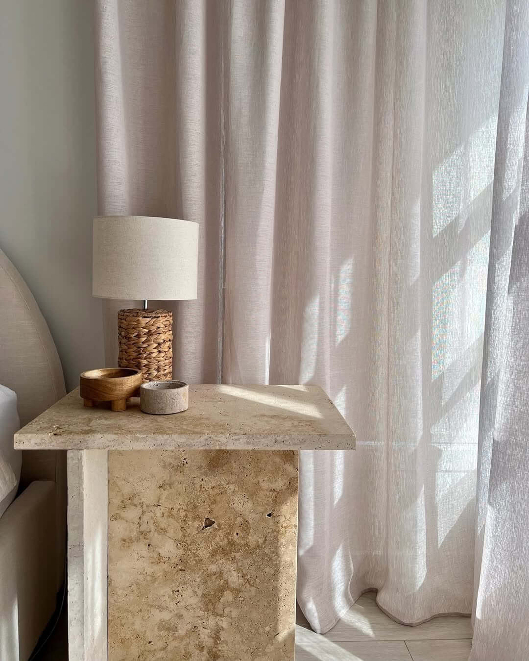 Travertine Pedestal Table Adds Natural Stone Texture to Bedroom