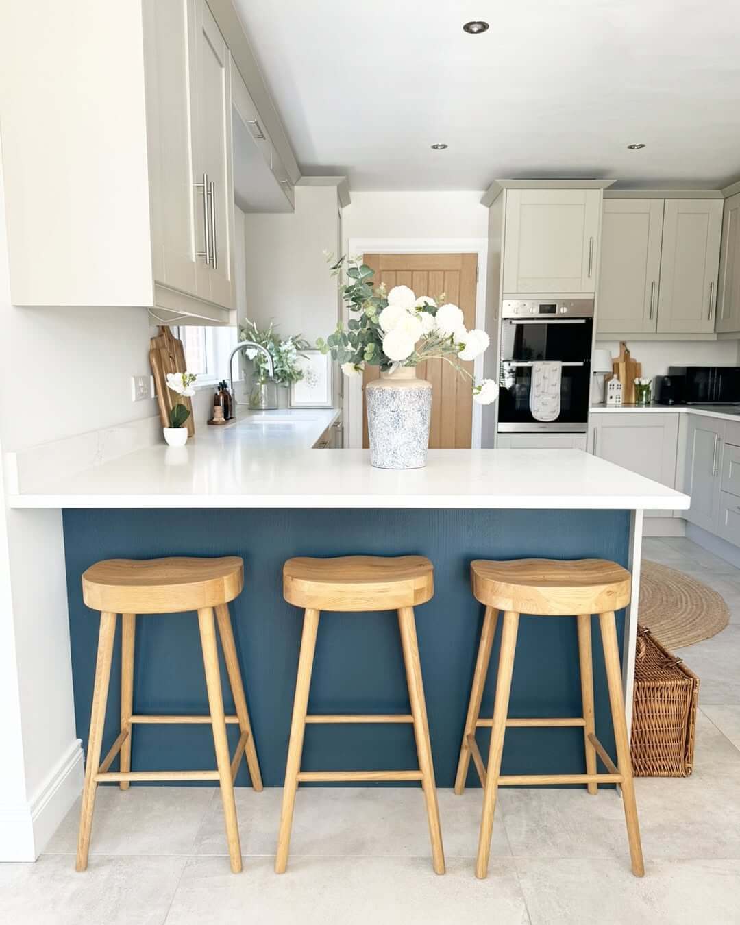 Natural Wood Stools Add Warmth to a Deep Blue Island