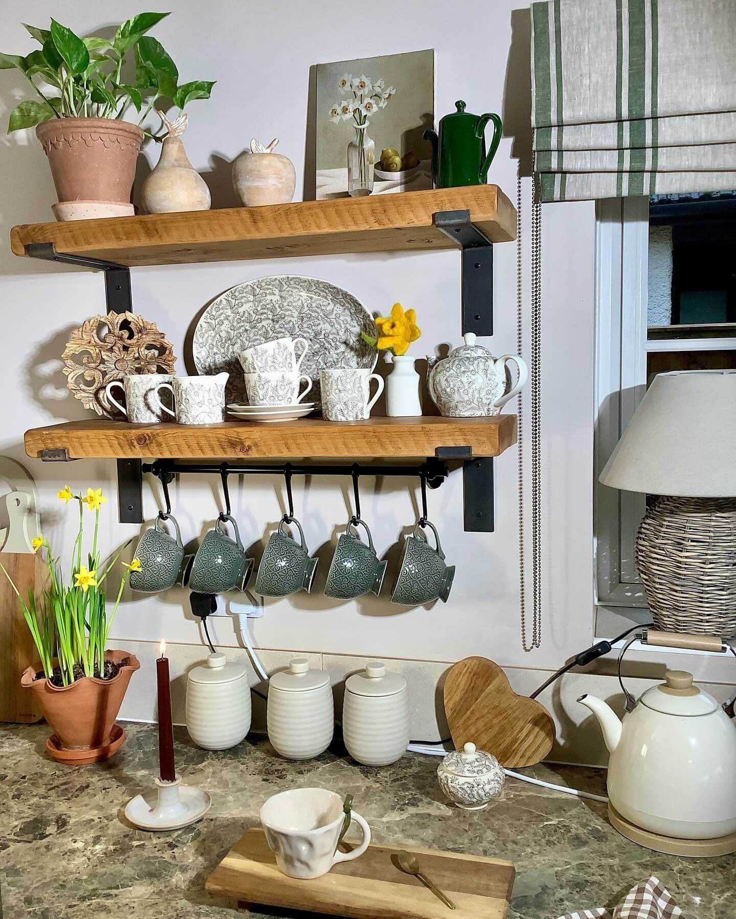 Mug hooks create a hanging display beneath kitchen shelves