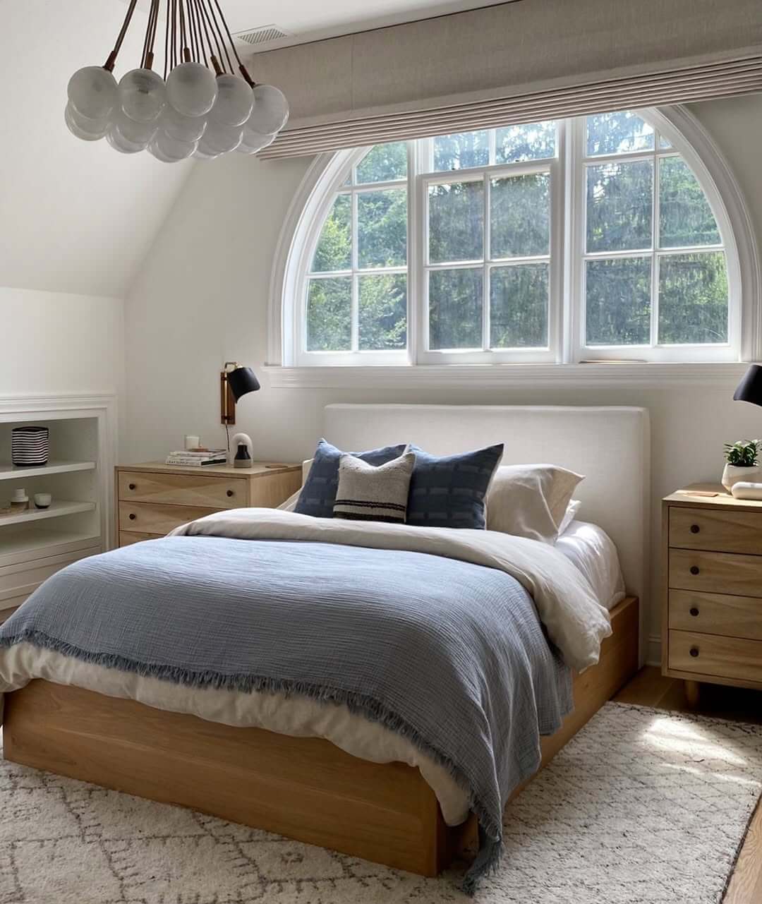 Arched Window Creates a Dramatic Focal Point Above the Bed