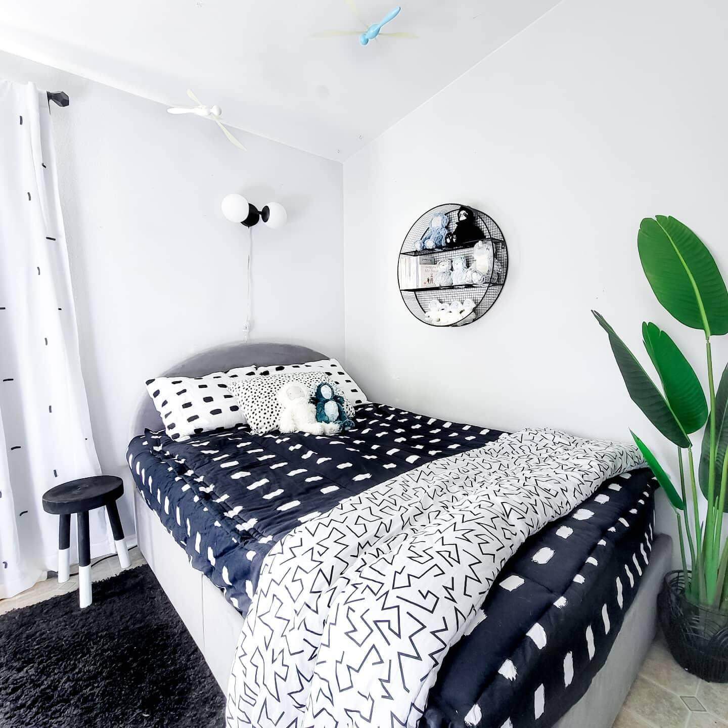 Graphic Bedding Layers Bold Patterns Above a Light Headboard