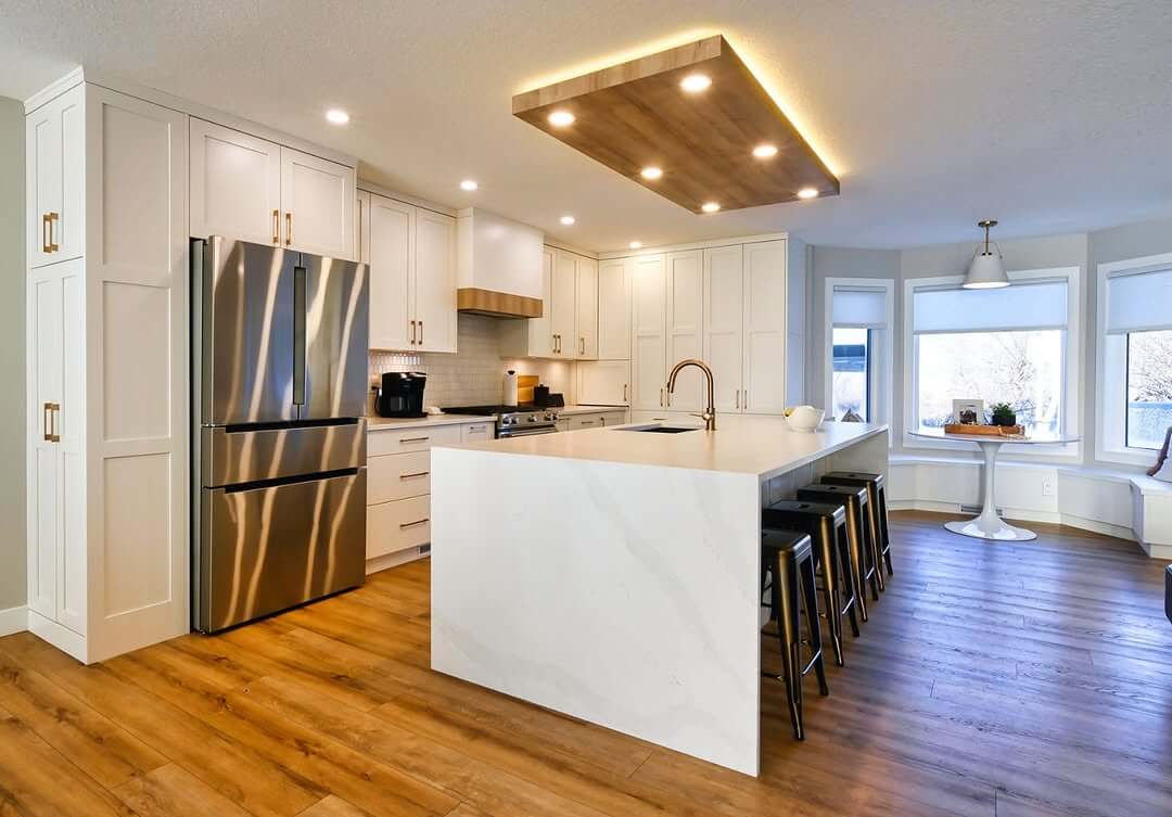 Recessed Ceiling Detail Adds Warm Wood Accent Above the Island