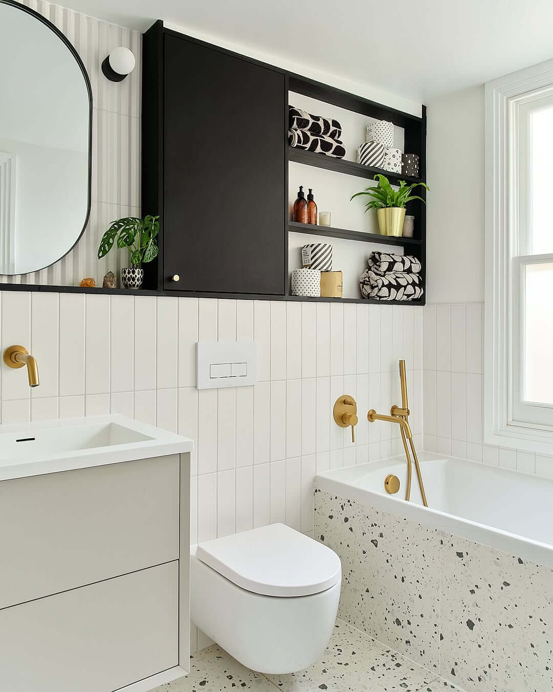 Black Open Shelving Displays Patterned Towels and Gold Accents