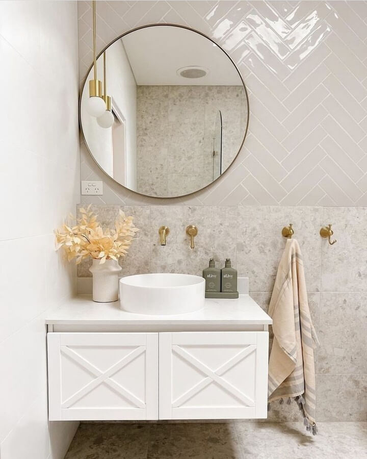 Round Mirror Reflects Warm Brass Fixtures and Herringbone Tile