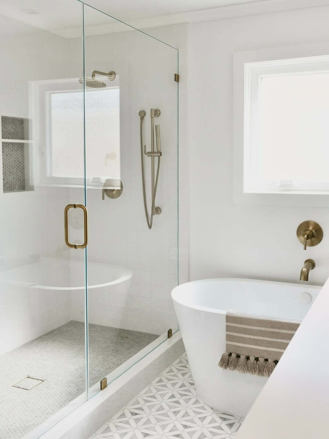 Geometric Floor Tile Grounds a White and Gold Bathroom